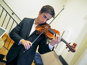 Violinist Gil Karam performs during reception 